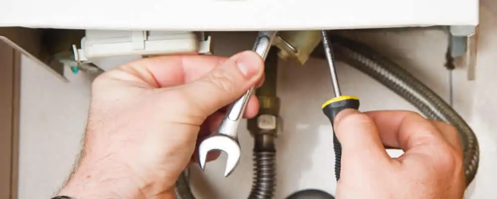 Boiler repair technician tightening pipe fittings and connections in Lancaster, PA