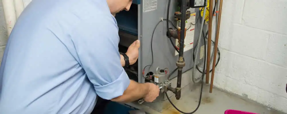 Furnace repair technician inspecting and servicing a home heating system in Lancaster, PA