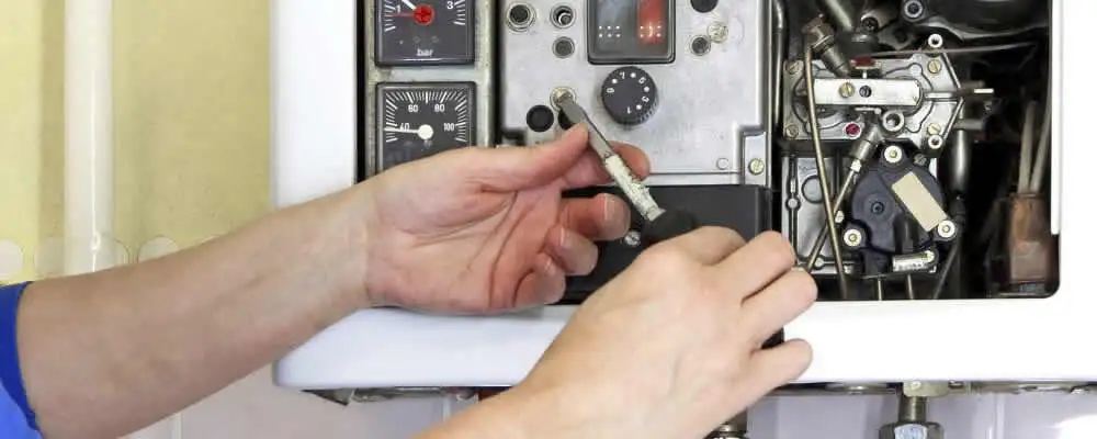 Heating repair technician adjusting boiler controls and components in Lancaster, PA