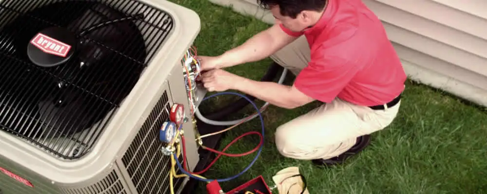 HVAC technician servicing an outdoor air conditioner unit in Lancaster, PA