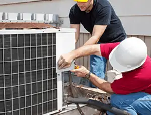 HVAC technicians repairing an outdoor AC unit on a rooftop in Lancaster, PA