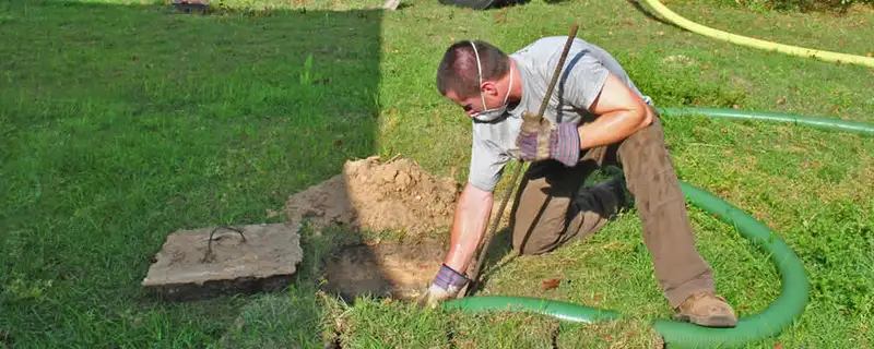 Septic pumping technician servicing a residential septic tank in Lancaster, PA
