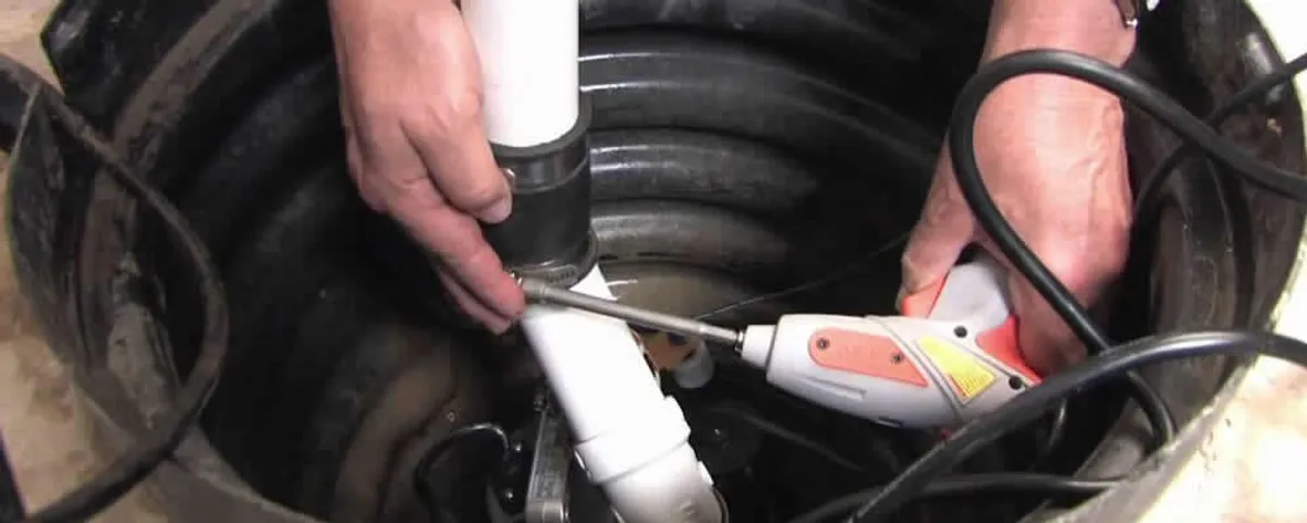 Sump pump installation technician connecting PVC discharge piping in Lancaster, PA