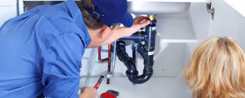 Plumber repairing under-sink drain pipes and fittings in Lancaster, PA